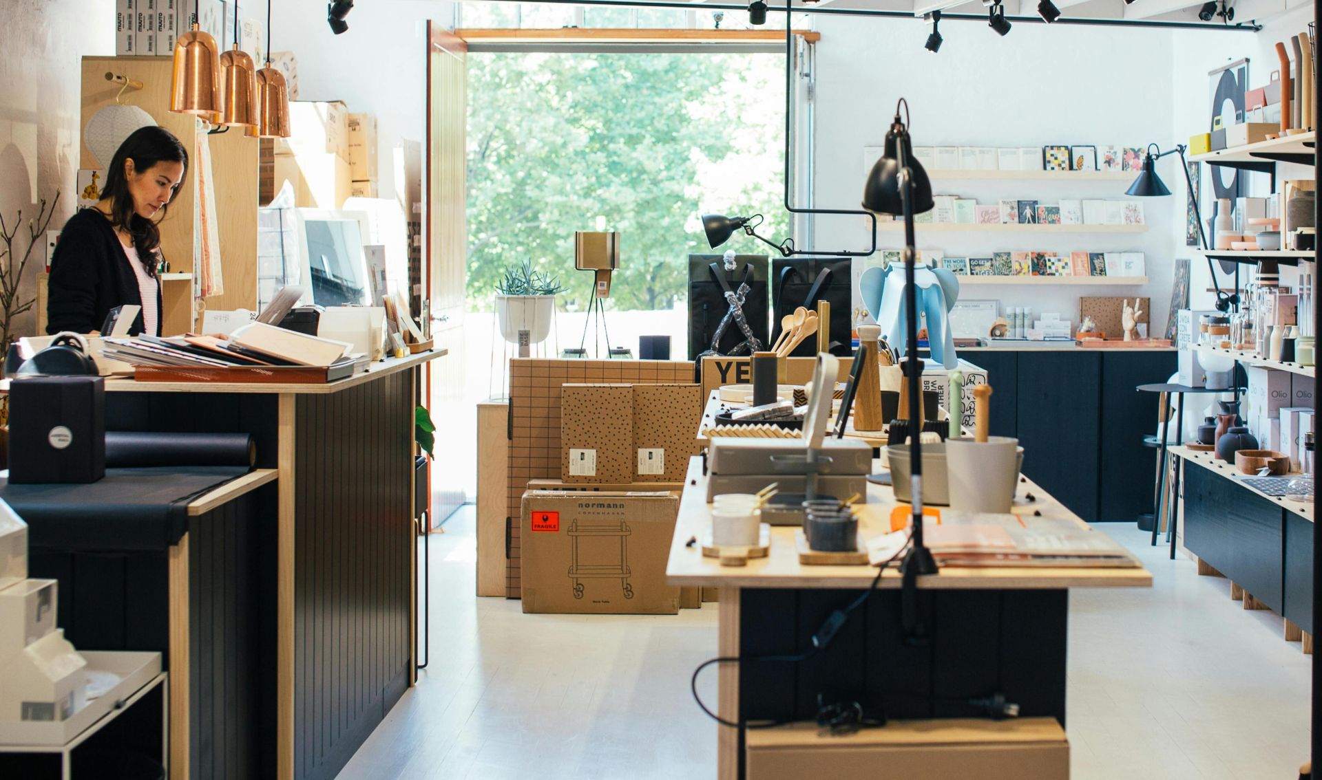 Trendy store interior featuring a female customer browsing surrounded by chic decor.